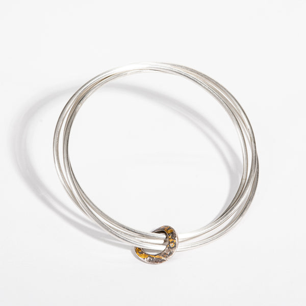 Oxidised 24-carat gold hoop, three sterling silver bangles