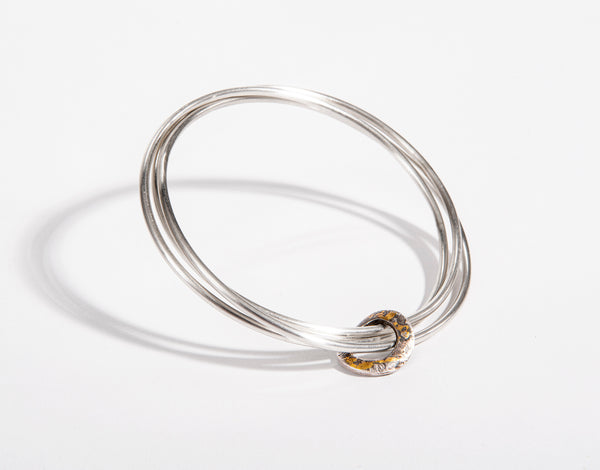 Oxidised 24-carat gold hoop, three sterling silver bangles
